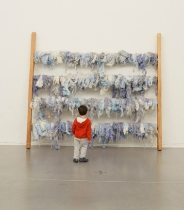 child in red in front of artwork